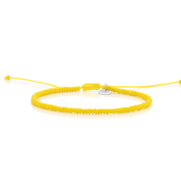 Handmade yellow bead bracelet with adjustable cord and silver charm