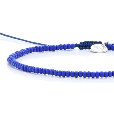 A close-up of the adjustable macrame knot and silver charm, a key feature of our blue stretch bead bracelets.