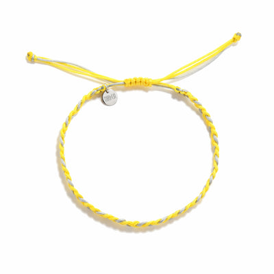 Flat lay of adjustable friendship bracelet made with yellow and gray thread and charm