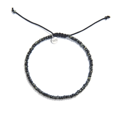 Flat lay of seed bead bracelet made with speckled black beads and black macrame closure