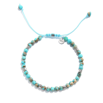 Turquoise jewelry bracelet with round beads and silver accents, displayed in a circular layout.