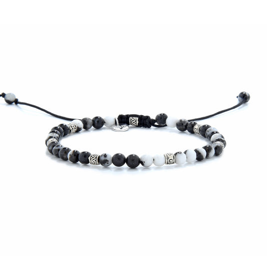 Flatlay of zebra jasper bracelet with adjustable black cord and silver decorative beads.