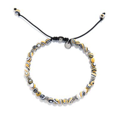 Adjustable black yellow bracelet featuring round man made malachite beads and silver spacers