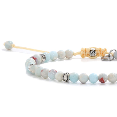 Side view of a Shoushan stone bracelet, showing its combination of soft blue and red-speckled beads, silver detailing, and knotted beige closure.