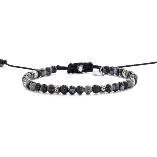 Full side view of the black stone bracelet laid out flat with black cord and adjustable clasp.