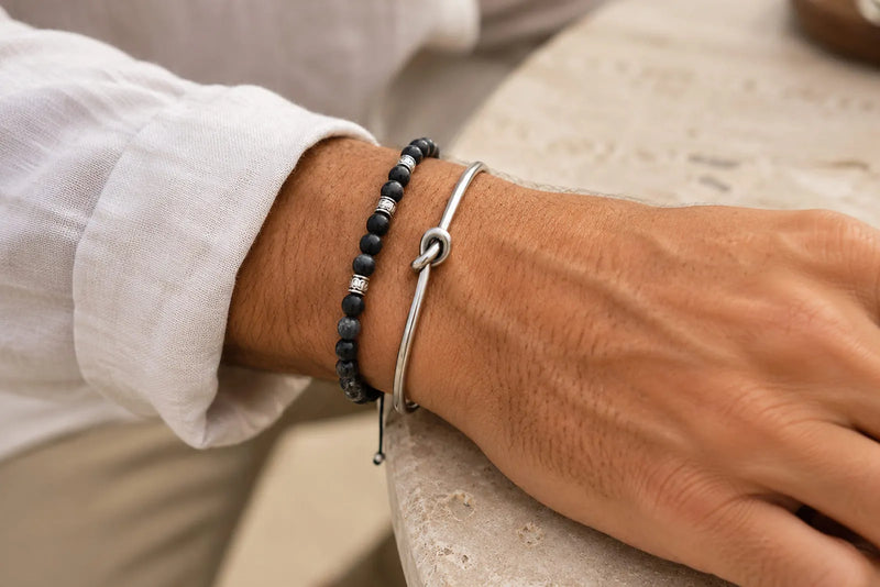 Black bead bracelet and silver cuff bracelet color combo worn with a white linen shirt
