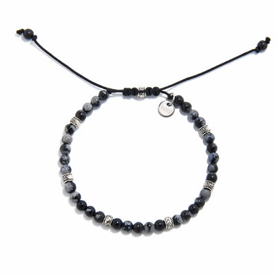 Adjustable bracelet black stone with polished jasper beads and silver detailing, laid flat.