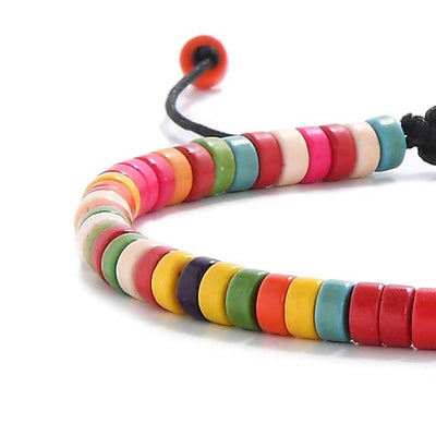 Close-up of a bracelet with colorful beads on black cord.