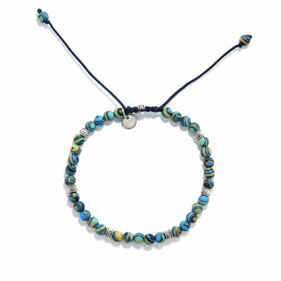 Bracelet malachite top view highlighting symmetrical beading and metal spacers on dark cord