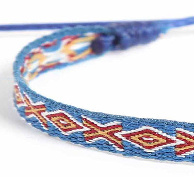 Blue braided bracelet with red and yellow geometric pattern close-up.