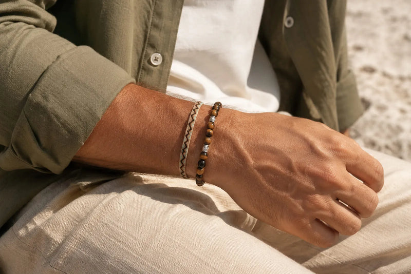 Brown and beige bracelet color combo worn with an olive overshirt and neutral trousers