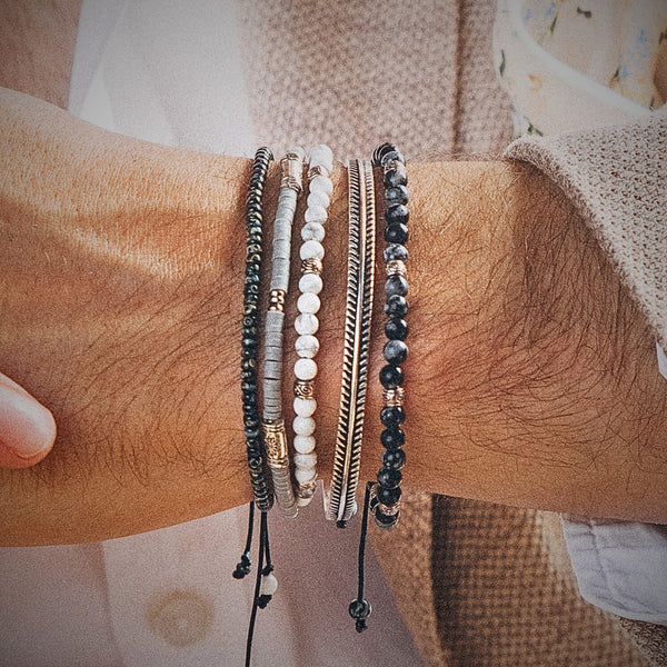 Close-up of men's wrist wearing Cannes bracelet set with black, white, and silver beads stacked for a bold look
