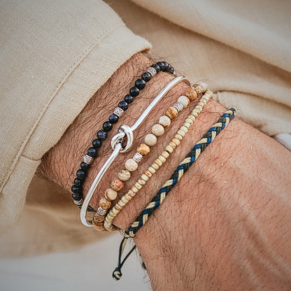 Neutral-toned men's bracelet stack with natural stones and a silver hook bracelet