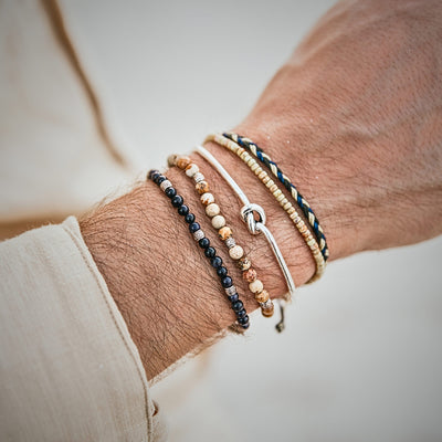 Side view of multi-strand bracelet stack with silver centerpiece and mixed beads