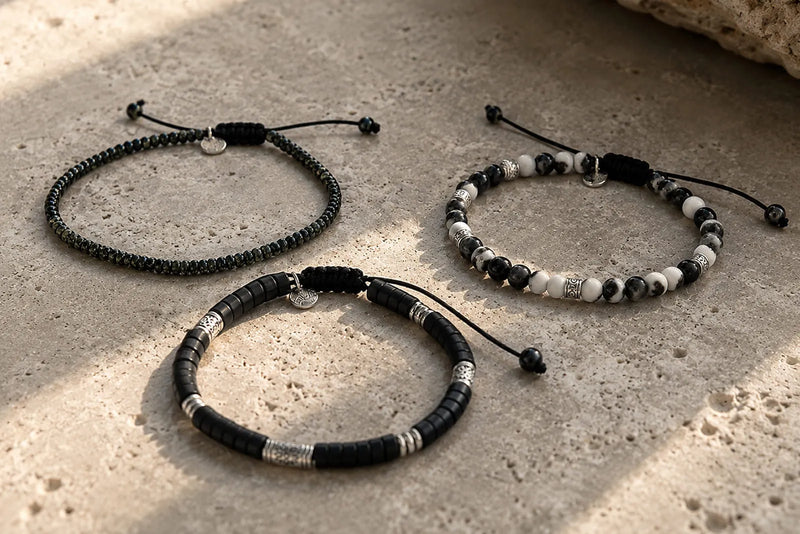 Three men's black bracelets made from seed beads, matte clay beads and black and white stone beads