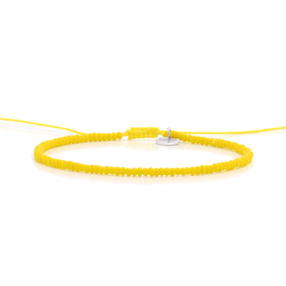Straight-on image of bracelets beads in yellow with silver disc charm

