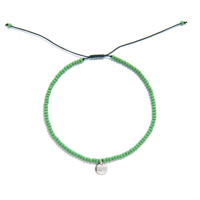 Overhead view of green beaded stretch bracelet in circular shape