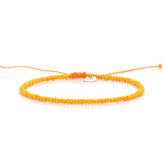 Horizontal display of orange men bead bracelet with charm