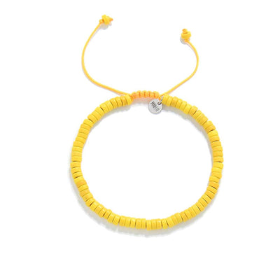 Overhead shot of adjustable yellow bracelet with round clay beads