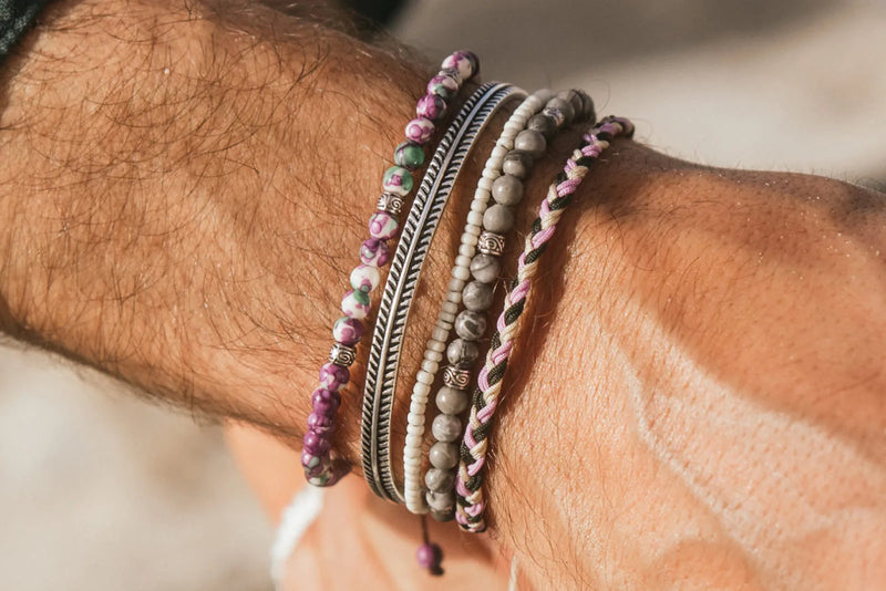 Gray Stone Jewelry styled in a men’s bracelet stack with silver, seed bead, and woven designs.