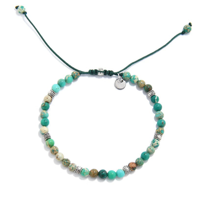 Top view of Green Jasper Bracelet with mixed green beads, silver spacers, green cord, and charm.