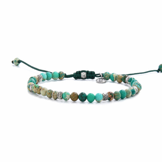  Side-angle shot of the green stone bracelet showing the full length of the beaded strand and the dark green sliding cord closure.