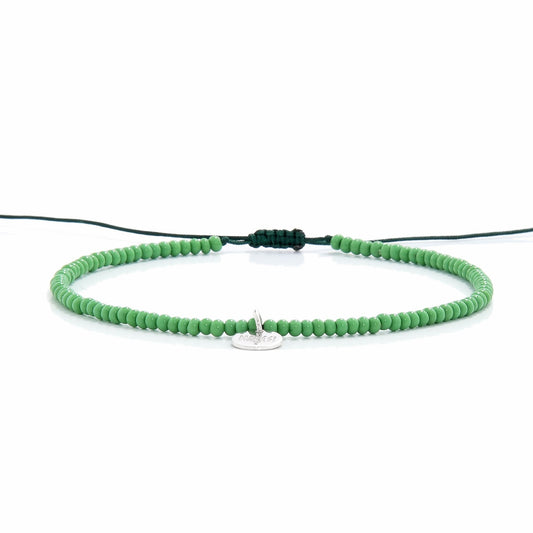 Minimalist green beaded stretch bracelet shown from side view

