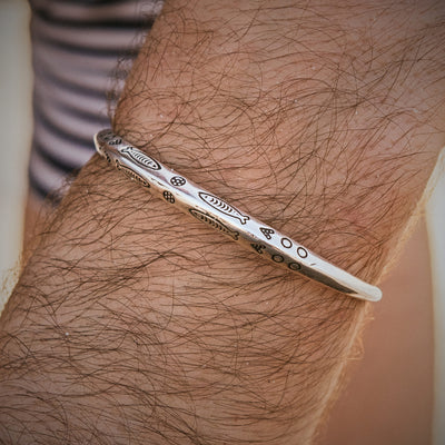 Men’s 925 sterling silver bracelet with engraved fish design worn on wrist