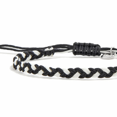 Close-up of handmade black and white friendship woven bracelet with macrame sliding knot