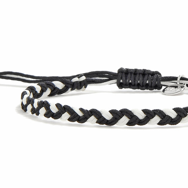 Close-up of handmade black and white friendship woven bracelet with macrame sliding knot