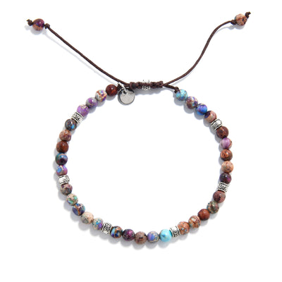 Top view of sea sediment jasper bracelet showing round beads in purple and blue tones