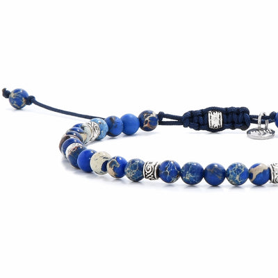 jasper stone bracelet close-up showing polished indigo beads with silver spacers and knot detail