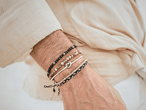 Man wearing layered stone bracelets