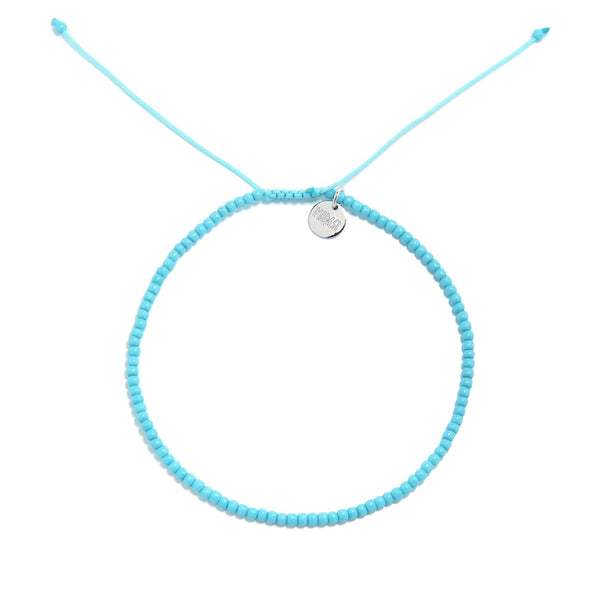  A top-down view of a light blue bracelet, an example of our mens beaded bracelets, arranged in a circle on a white background.