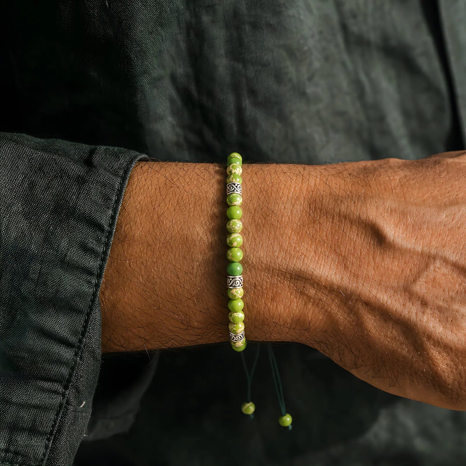 Light Green Stone Bracelet worn on a wrist with beaded design and adjustable cord
