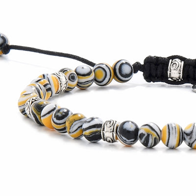 Malachite beads bracelet with striped yellow, black, and white gemstones.
