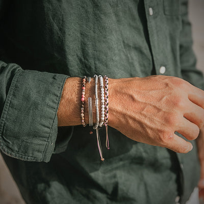 Mallorca bracelet set worn with green shirt, showing a colorful couples bracelet set with beaded and braided styles.