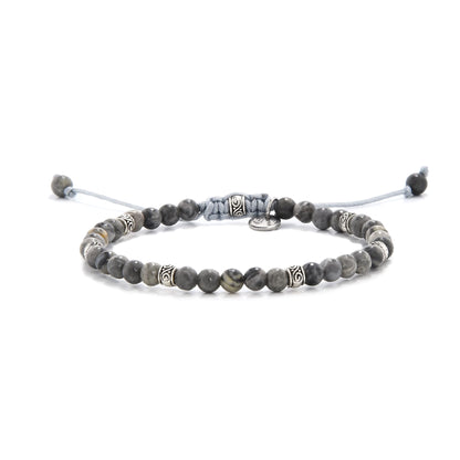Gray jasper bracelet with silver accents and adjustable cord, styled on white background