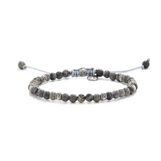 Gray jasper bracelet with silver accents and adjustable cord, styled on white background