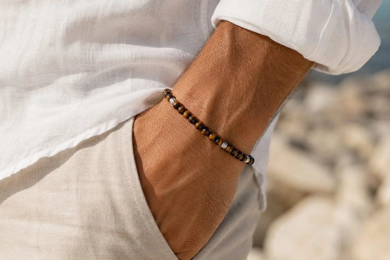 Men’s summer style with a Tiger Eye bracelet, white linen shirt and lightweight beige trousers.