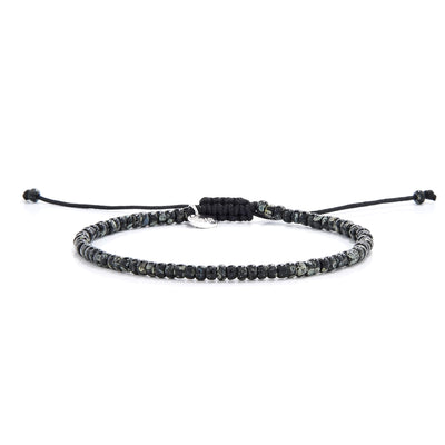 Minimalist seed bead bracelet featuring speckled black beads and sliding knot closure