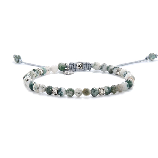 Full view of the moss agate bracelet laid flat, showing an even distribution of green, white, and speckled beads with metal details.