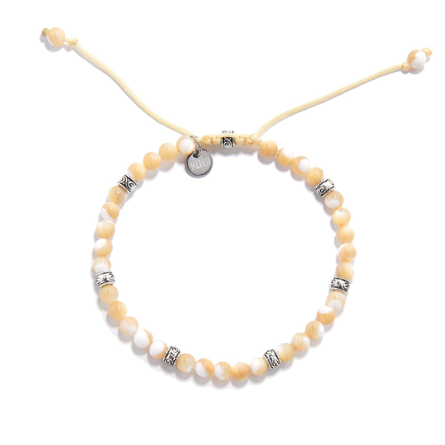  Top-down view of the mother of pearl bracelet arranged in a circle, showing uniform beading and engraved silver accents.