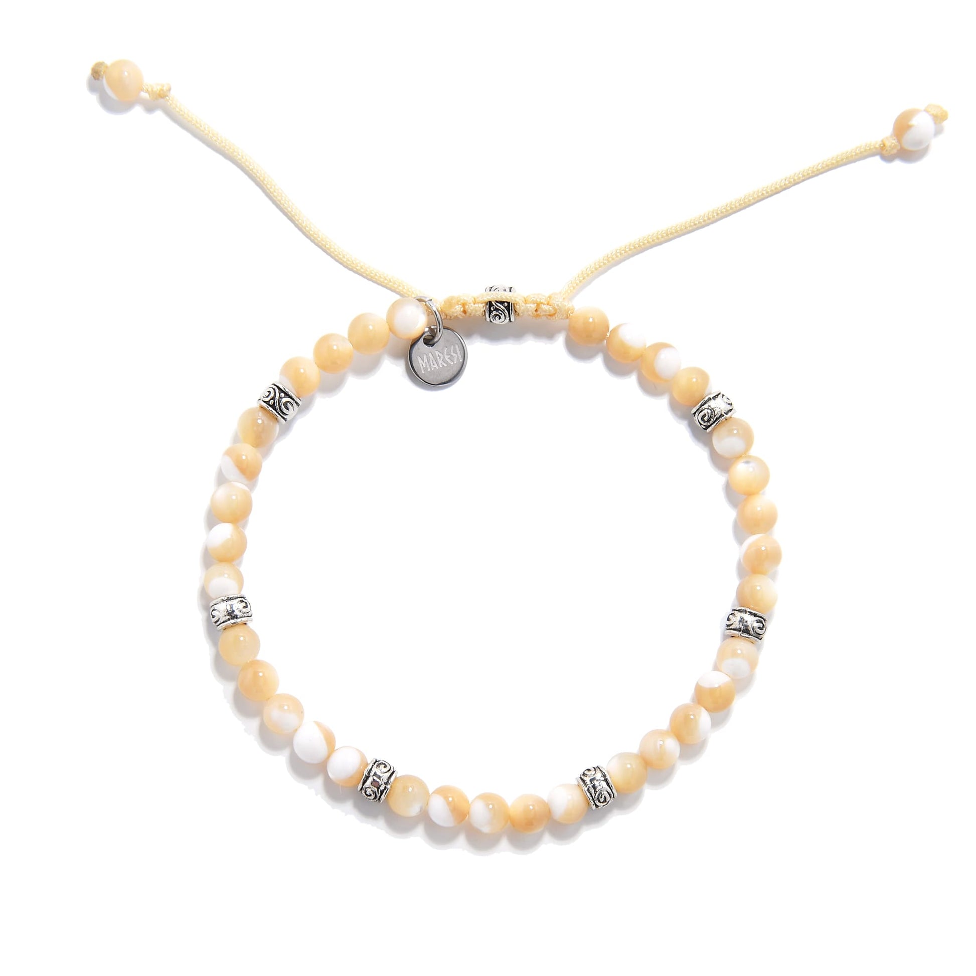  Top-down view of the mother of pearl bracelet arranged in a circle, showing uniform beading and engraved silver accents.