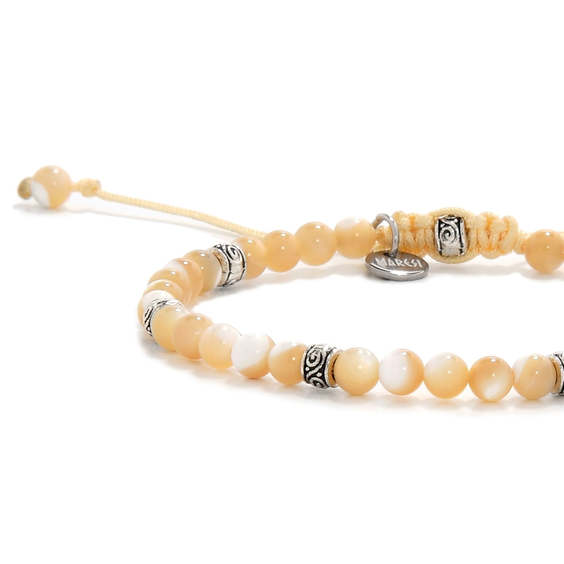 Side angle of the bracelet highlighting the smooth texture of the beads and the braided closure with Maresi tag.