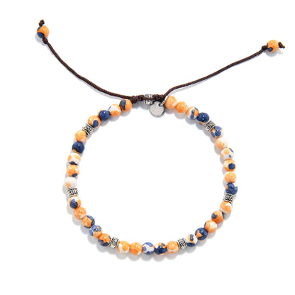 Orange Flower Jasper bracelet with blue and white marbled beads, viewed from above on a white background