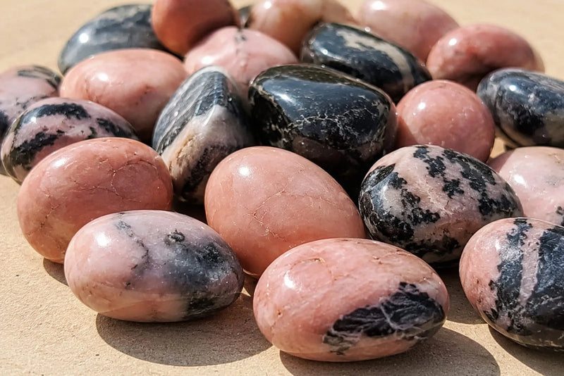 Polished pink stones with dark patches and veins