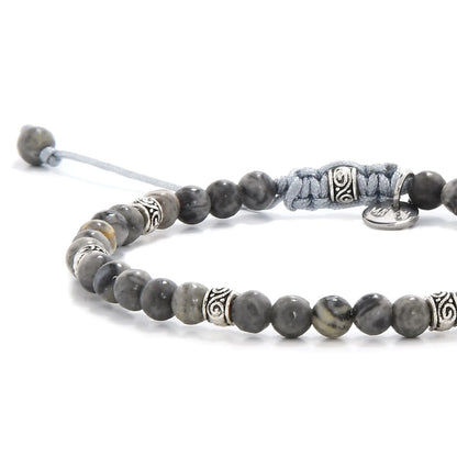 Close-up of polished gray stone beads with silver accent spacers.