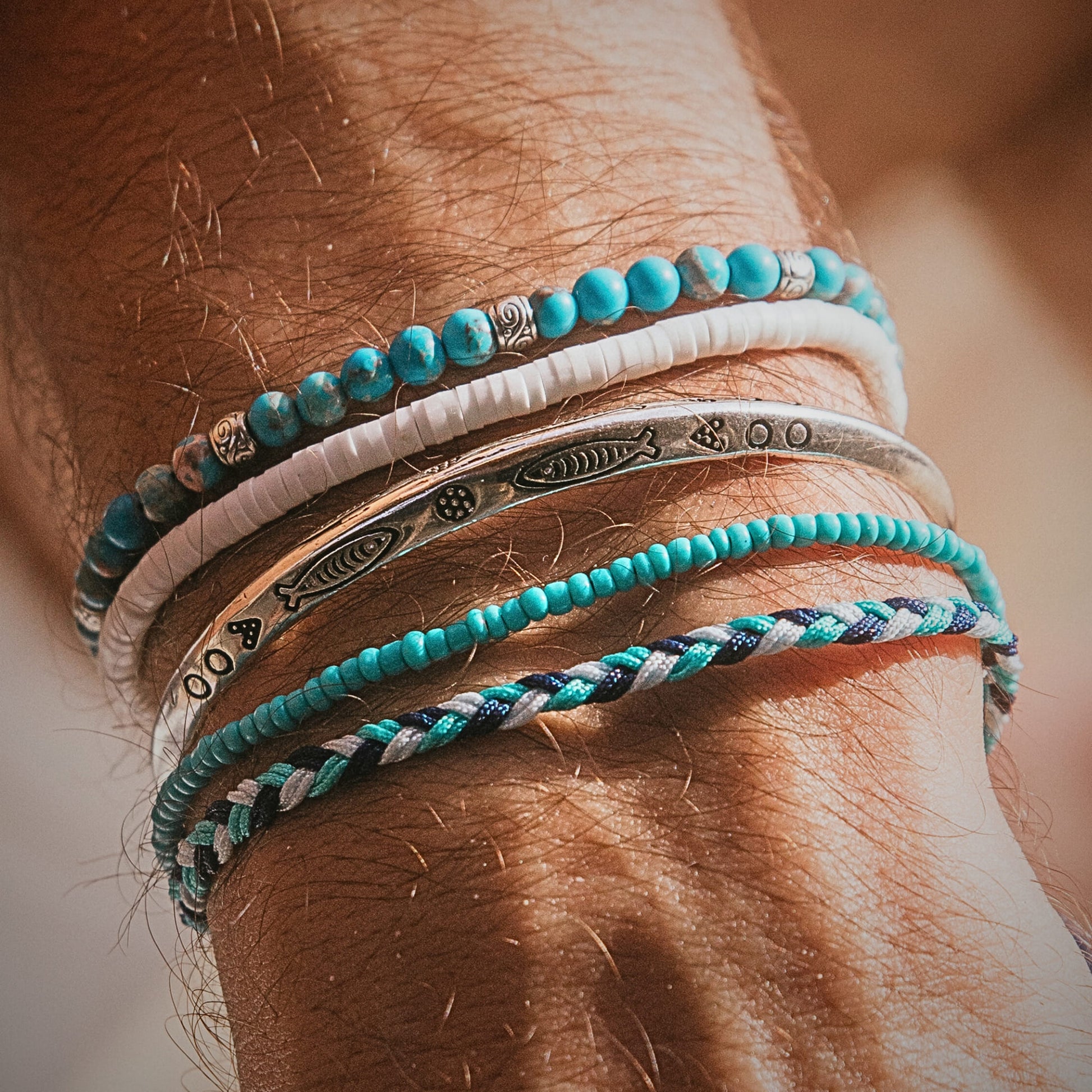 Detailed view of stacked Positano bracelets with white, silver, and blue beaded textures.