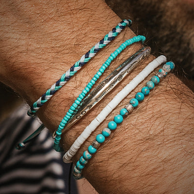 Side angle of Positano bracelet set on wrist, showing multiple layered silver and turquoise stack bracelets.